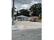 Front of house featuring an expansive driveway, and neutral tones accented by rock facade at 7022 Hubert, Tampa, FL 33614