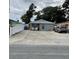 Charming single-story home with a spacious driveway, stone columns, and inviting front porch seating at 7022 Hubert, Tampa, FL 33614