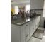 Kitchen counter features granite countertops, a stainless steel sink, and white cabinets at 7022 Hubert, Tampa, FL 33614