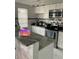 Stylish kitchen featuring granite countertops, white cabinets, stainless steel appliances, and modern lighting at 7022 Hubert, Tampa, FL 33614