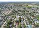 A sweeping aerial view of a vibrant residential area featuring tree-lined streets and diverse housing options at 7040 Fox Hollow Dr, Port Richey, FL 34668