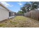 Fenced in backyard features an enclosed patio and space for outdoor activities at 7040 Fox Hollow Dr, Port Richey, FL 34668