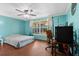 Bright bedroom features a ceiling fan, large window, and wood-look flooring at 7040 Fox Hollow Dr, Port Richey, FL 34668
