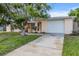Charming single-story home featuring a front lawn and an attached two-car garage at 7040 Fox Hollow Dr, Port Richey, FL 34668