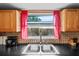 Kitchen sink with dual basin and modern faucet beneath bright window at 7040 Fox Hollow Dr, Port Richey, FL 34668