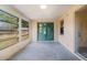 Enclosed patio with sliding glass doors, multiple windows, and concrete floor offers a versatile space at 7040 Fox Hollow Dr, Port Richey, FL 34668