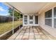 The covered patio features colorful tile flooring and an entrance to the home at 7040 Fox Hollow Dr, Port Richey, FL 34668