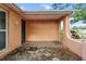 Inviting covered porch with a tiled floor and decorative plants at 7040 Fox Hollow Dr, Port Richey, FL 34668