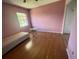 Small bedroom with pink walls, plank flooring, and a window at 7192 E Bank Dr, Tampa, FL 33617