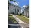 Exterior of a two-story townhouse featuring green grass and sidewalks at 7192 E Bank Dr, Tampa, FL 33617