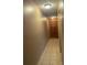 Hallway with tiled flooring and a wooden door at the end at 7192 E Bank Dr, Tampa, FL 33617