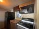 Kitchen featuring dark cabinets, black appliances, and tiled countertops at 7192 E Bank Dr, Tampa, FL 33617