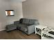 Cozy living room with a grey sofa, ottoman, and side tables at 7192 E Bank Dr, Tampa, FL 33617