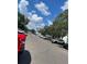 Street view of neighborhood with parked cars and lush trees underneath a blue sky at 7192 E Bank Dr, Tampa, FL 33617