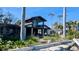Home's exterior elevation displaying a modern design, expansive windows, mature landscaping, and some visible damage at 720 Boca Ciega Isle Dr, St Pete Beach, FL 33706