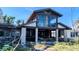 Exterior elevation of a modern home with two-story window features, mature landscaping and some visible damage at 720 Boca Ciega Isle Dr, St Pete Beach, FL 33706