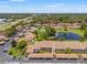 Aerial view of a community featuring a pool, lake, carports, and well-maintained landscaping at 7614 Radcliffe Cir # 202B, Port Richey, FL 34668