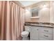 Tiled bathroom with a granite-topped vanity, matching mirror, and shower curtain at 7614 Radcliffe Cir # 202B, Port Richey, FL 34668