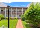 Inviting condo exterior featuring a well-maintained lawn and pathway to the entrance at 7614 Radcliffe Cir # 202B, Port Richey, FL 34668