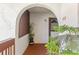Charming porch with arched entryway and a decorative plant enhancing the welcome to unit 202 at 7614 Radcliffe Cir # 202B, Port Richey, FL 34668