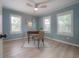 Bedroom with wood floors, desk, fan and two windows for plenty of natural light at 811 W Peninsular St, Tampa, FL 33603