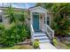 Charming home featuring a blue front door, well-kept landscaping, and inviting entrance steps at 811 W Peninsular St, Tampa, FL 33603