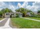Charming one-story home featuring a well-manicured lawn and a welcoming blue front door at 811 W Peninsular St, Tampa, FL 33603