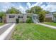 A charming, bright yellow home with lush lawn, and welcoming blue front door at 811 W Peninsular St, Tampa, FL 33603