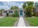 Charming single-story home featuring a light-colored exterior and a well-manicured front yard at 811 W Peninsular St, Tampa, FL 33603