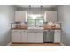 Bright kitchen featuring a farmhouse sink, modern fixtures, butcher block countertops, and white cabinetry at 811 W Peninsular St, Tampa, FL 33603