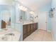 Double sink bathroom with tiled flooring and blue accent wall at 835 Symphony Isles Blvd, Apollo Beach, FL 33572