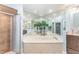 Luxurious bathroom with a soaking tub, separate shower, and large mirror at 835 Symphony Isles Blvd, Apollo Beach, FL 33572