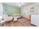 A charming Bedroom with a white crib, rocker, and coordinated decor on wood floors at 835 Symphony Isles Blvd, Apollo Beach, FL 33572