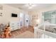 Bright Bedroom featuring a changing table, crib, and decorative accents on wood floors at 835 Symphony Isles Blvd, Apollo Beach, FL 33572