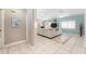 Spacious living room featuring tile flooring, a large sofa, and a view into other areas of the house at 835 Symphony Isles Blvd, Apollo Beach, FL 33572