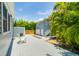 View of the detached garage and backyard, featuring a concrete patio and white Adirondack chair at 842 S Boulevard, Tampa, FL 33606