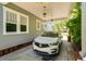 Carport showcasing a modern vehicle, with an inviting home exterior and well-maintained landscaping at 842 S Boulevard, Tampa, FL 33606