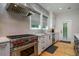 Contemporary kitchen featuring stainless steel appliances, sleek white cabinetry, and a professional-grade range with red knobs at 842 S Boulevard, Tampa, FL 33606