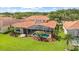 Aerial shot of a gorgeous home with screened pool, terracotta roof, and lush green yard at 8476 Dunham Station Dr, Tampa, FL 33647
