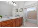 Bathroom with double sinks, wood cabinets, and a shower-tub combination at 8476 Dunham Station Dr, Tampa, FL 33647