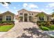 Beautiful two-story home with brick driveway, three car garage, manicured lawn and tropical landscaping at 8476 Dunham Station Dr, Tampa, FL 33647