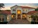 Elegant two-story home with a brick driveway, terracotta roof, mature palms and symmetrical design at 8476 Dunham Station Dr, Tampa, FL 33647