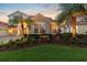 Beautiful home with terracotta roof, green lawn, mature landscaping, and a brick driveway at 8476 Dunham Station Dr, Tampa, FL 33647