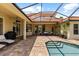The screened pool is surrounded by a brick patio with seating at 8476 Dunham Station Dr, Tampa, FL 33647