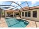 Backyard view of the screened in pool with a brick surround at 8476 Dunham Station Dr, Tampa, FL 33647