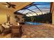 Evening view of the screened pool and patio with a fire pit and fountain at 8476 Dunham Station Dr, Tampa, FL 33647