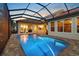 Illuminated screened-in pool and patio at dusk offers a tranquil setting at 8476 Dunham Station Dr, Tampa, FL 33647