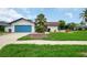 Charming single-story home with a lush lawn and inviting blue garage door, perfect for curb appeal at 8635 Chadwick Dr, Tampa, FL 33635
