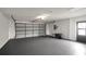 Spacious garage with painted floor, overhead lighting and garage door at 8635 Chadwick Dr, Tampa, FL 33635