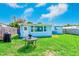 Charming backyard with a grill, lush green grass, and a light blue home at 10436 117Th Dr, Largo, FL 33773